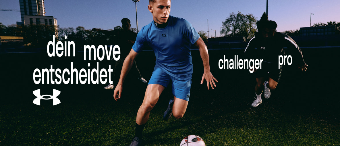 Drei junge Männer spielen abends Fußball in Under Armour Sportkleidung.