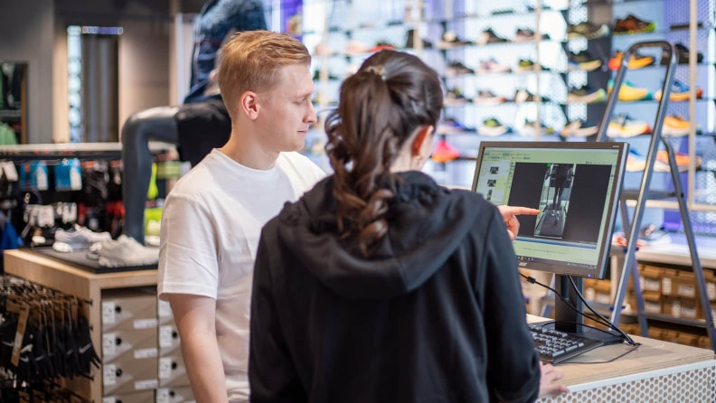 Kundin wird in ihrem INTERSPORT Shop gerade zur Laufanalyse beraten.