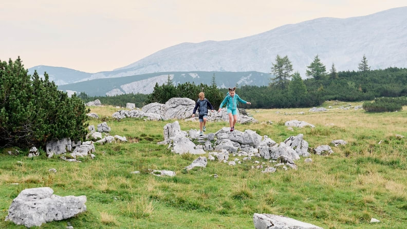 Zwei Kinder wandern durch die Natur.
