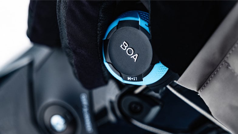 Nahaufnahme eines blau-schwarzen BOA-Verschlusssystems an einem technischen Produkt.