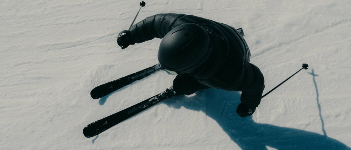 Eine Skifahrerin in Schwarz fährt mit Atomic Cloud Ski die Piste hinunter.