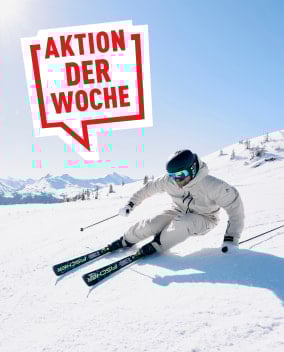 Ein Skifahrer auf einer verschneiten Piste mit Werbebanner 'Aktion der Woche'.