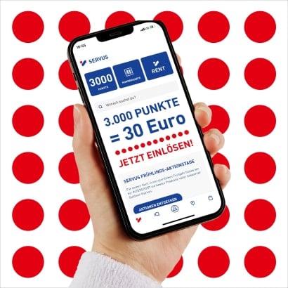 Zwei Hände halten und zeigen auf ein Handy mit der geöffneten INTERSPORT App.