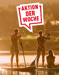 Gruppe beim Stand-up-Paddling auf einem See im goldenen Abendlicht mit Banner Aktion der Woche