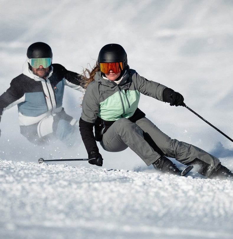 Zwei Skifahrer bei der Abfahrt mit Skibekleidung von McKINLEY