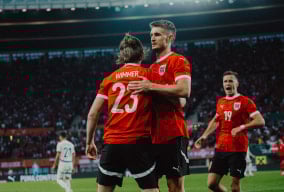Österreichische Fußballspieler feiern nach einem Torerfolg in einem Stadion.