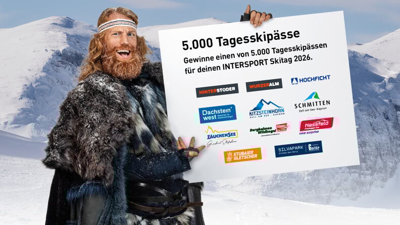 Der Winter hält ein Schild auf dem geschrieben steht: Gewinne einen von 5.000 Tagesskipässen für deinen INTERSPORT Skitag 2026.