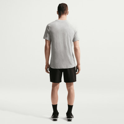 Ein Mann in einem grauen T-Shirt und schwarzer Hose steht mit dem Rücken zur Kamera.