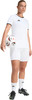 Eine Frau im weißen Fußballtrikot und Shorts hält einen Ball.