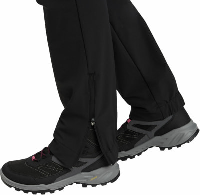 Schwarze Outdoorhose mit seitlichem Reißverschluss am Knöchel und Sportschuh. Schwarze Outdoorhose mit seitlichem Reißverschluss am Knöchel und Sportschuh.