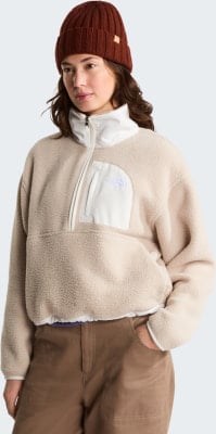 Frau in beige Fleece-Pullover mit weißem Kragen und brauner Hose. Frau in beige Fleece-Pullover mit weißem Kragen und brauner Hose.