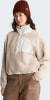 Frau in beige Fleece-Pullover mit weißem Kragen und brauner Hose.
