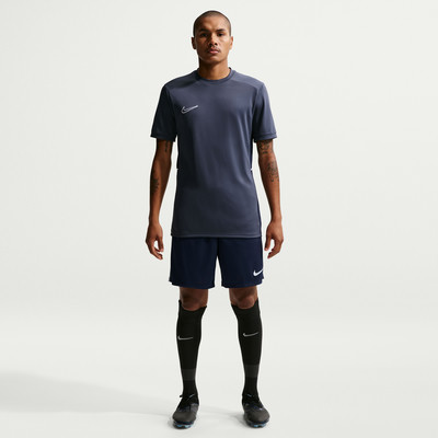 Ein Mann in dunkelblauer Nike Sportbekleidung steht vor einem weißen Hintergrund. Ein Mann in dunkelblauer Nike Sportbekleidung steht vor einem weißen Hintergrund.