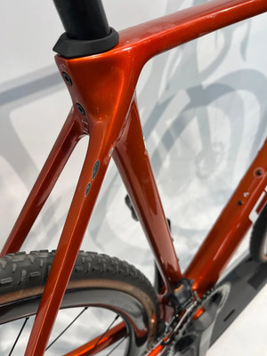 Nahaufnahme des Rahmens eines orangefarbenen Fahrrads mit sichtbaren Schrauben und Reifen. Nahaufnahme des Rahmens eines orangefarbenen Fahrrads mit sichtbaren Schrauben und Reifen.