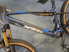 Ein blaues Mountain-E-Bike mit Dämpfer und goldenen Gabeln.