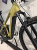 Ein goldenes E-Bike mit schwarzer Gabel und Dämpfer steht auf einem Ständer.