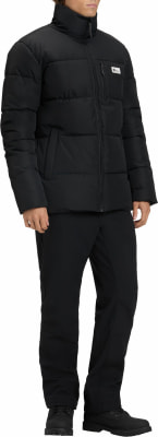 Ein Mann in schwarzer Daunenjacke und Hose steht und posiert. Ein Mann in schwarzer Daunenjacke und Hose steht und posiert.