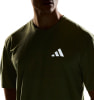 Mann in einem grünen T-Shirt mit Adidas-Logo auf der Brust.