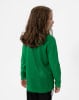 Mädchen mit braunen Haaren in einem grünen Langarmshirt und schwarzer Hose.