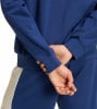 Detail von Ärmel und Händen in blauer Kleidung, mit einem beige Streifen an der Seite.