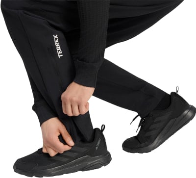 Schwarze Sporthose mit weißem Terrex-Schriftzug und schwarzen Schuhen. Schwarze Sporthose mit weißem Terrex-Schriftzug und schwarzen Schuhen.