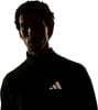 Mann in schwarzem Shirt mit Adidas-Logo, Silhouette vor weißem Hintergrund.