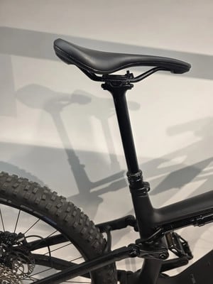 Eine schwarze Sattelstütze mit schwarzem Sattel an einem Mountainbike. Eine schwarze Sattelstütze mit schwarzem Sattel an einem Mountainbike.
