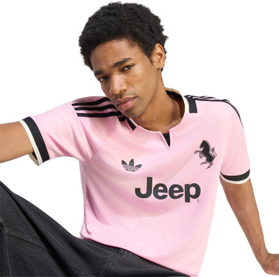 Junger Mann in einem rosa T-Shirt mit Adidas-Logo und Jeep-Aufdruck. Junger Mann in einem rosa T-Shirt mit Adidas-Logo und Jeep-Aufdruck.