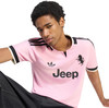 Junger Mann in einem rosa T-Shirt mit Adidas-Logo und Jeep-Aufdruck.