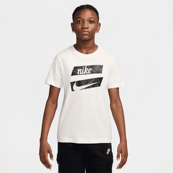 Mädchen in einem weißen T-Shirt mit Nike-Logo und schwarzem Muster.