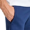 Eine Männerhand in einer dunkelblauen Hosentasche mit einem weißen Oberteil.