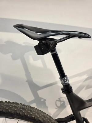 Eine Mountainbike-Sattelstütze mit einem unter dem Sattel befestigten Controller.
