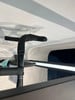 Schwarzer Fahrradlenker mit umwickeltem Lenkerband und Schatten an der weißen Wand.