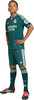 Junge in grüner Fußballkleidung mit Real Madrid und Adidas Logo.