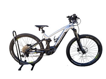 Silbernes E-Mountainbike auf einem Ständer mit schwarzen Rädern und Federung.