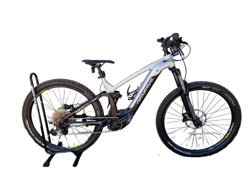 Silbernes E-Mountainbike auf einem Ständer mit schwarzen Rädern und Federung.