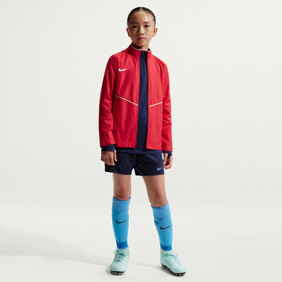 Mädchen in roter Jacke, dunkelblauen Shorts und hellblauen Socken. Mädchen in roter Jacke, dunkelblauen Shorts und hellblauen Socken.
