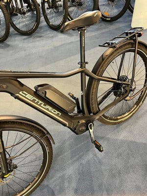 Schwarzes E-Bike mit Batteriefach und Gepäckträger im Hintergrund. Schwarzes E-Bike mit Batteriefach und Gepäckträger im Hintergrund.
