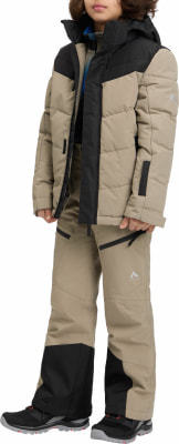 Junge in beiger Daunenjacke und Skihose mit schwarzen Akzenten. Junge in beiger Daunenjacke und Skihose mit schwarzen Akzenten.