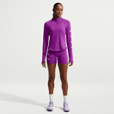 Frau in lila Laufkleidung mit Nike-Logo und Reflektoren. Frau in lila Laufkleidung mit Nike-Logo und Reflektoren.
