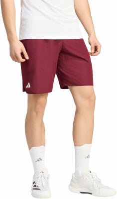 Mann in dunkelroten Shorts mit weißem T-Shirt und weißen Turnschuhen.