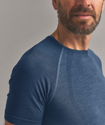 Nahaufnahme eines Mannes in einem dunkelblauen Kurzarmshirt mit Schulternaht. Nahaufnahme eines Mannes in einem dunkelblauen Kurzarmshirt mit Schulternaht.