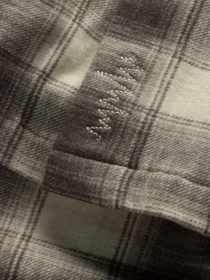 Detail eines karierten Stoffes mit gesticktem Muster am Saum. Detail eines karierten Stoffes mit gesticktem Muster am Saum.