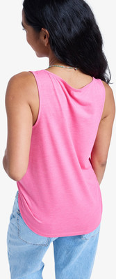 Frau in einem pinken Tanktop und Jeans mit einer Perlenkette. Frau in einem pinken Tanktop und Jeans mit einer Perlenkette.