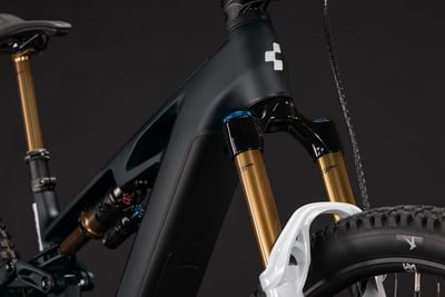 Detail eines Mountainbike-E-Bikes mit Federung und goldenen Gabeln.