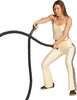 Eine Frau in Beige trainiert mit einem Seil im Fitnessstudio.