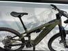 Grünes Mountainbike mit Federung und breiten Reifen.