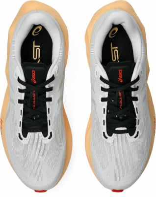 Draufsicht auf hellgraue Laufschuhe mit orangefarbener Sohle. Draufsicht auf hellgraue Laufschuhe mit orangefarbener Sohle.