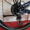 Detail der hinteren Schaltung und Kassette an einem dunkelblauen Fahrrad.