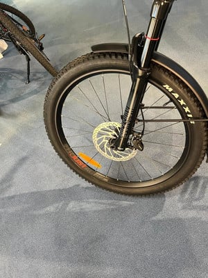 Vorderreifen eines schwarzen Mountainbikes mit Scheibenbremse und Schutzblech. Vorderreifen eines schwarzen Mountainbikes mit Scheibenbremse und Schutzblech.